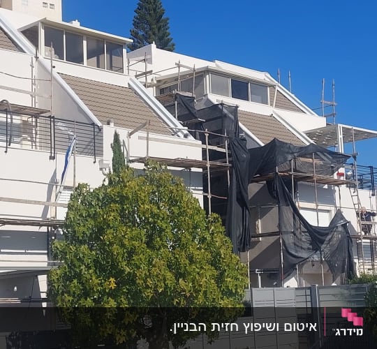 פיגומים שהוקמו על קיר חיצוני של בית למטרת עבודות איטום